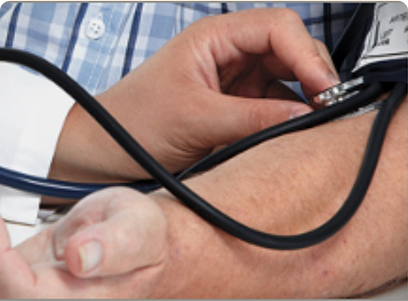 A person is checking another's blood pressure using a sphygmomanometer and stethoscope.