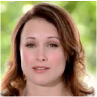 A woman with brown hair smiling softly with blurred green background.